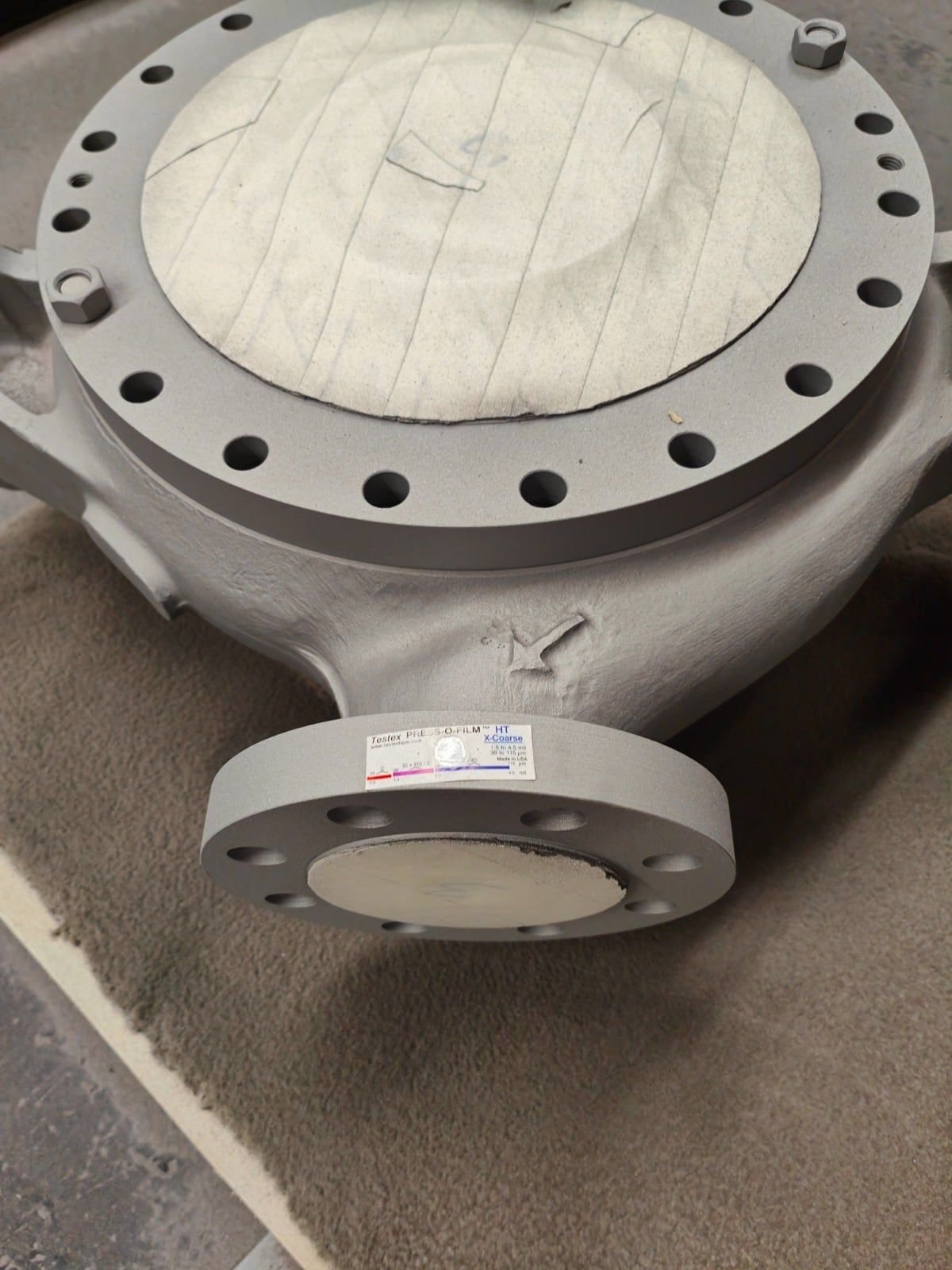 Blast-cleaned and coated pump casing with masked flanges and a strip of replica tape on one flange